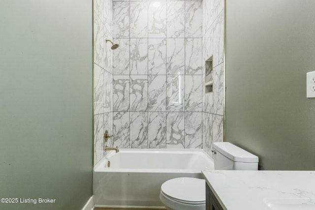 full bathroom with vanity, tiled shower / bath combo, and toilet