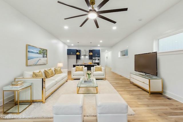 living room featuring ceiling fan and light hardwood / wood-style flooring