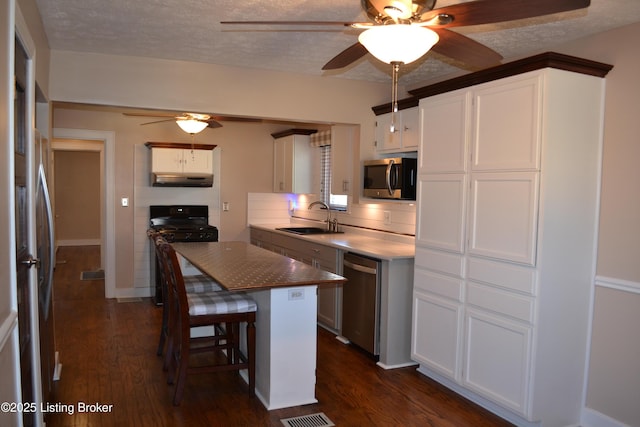 kitchen with appliances with stainless steel finishes, sink, and white cabinets