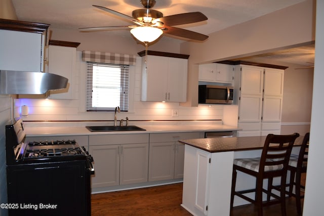 kitchen with black range with gas cooktop, a center island, sink, and white cabinets