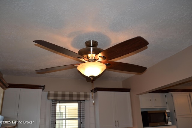 room details with ceiling fan and a textured ceiling