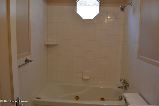 bathroom with tile walls and tiled shower / bath combo