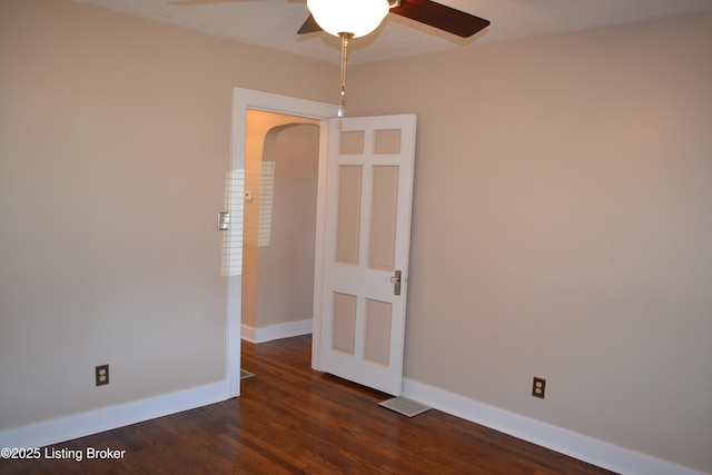 empty room featuring dark hardwood / wood-style flooring and ceiling fan