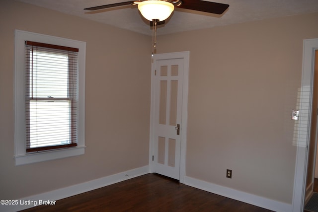 spare room with dark wood-type flooring and ceiling fan