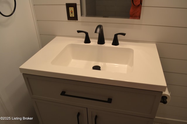 bathroom featuring vanity and wooden walls