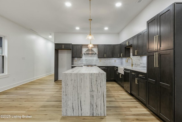 kitchen with a kitchen island, dishwasher, hanging light fixtures, light hardwood / wood-style floors, and wall chimney exhaust hood