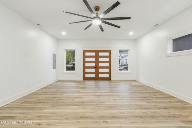 interior space featuring ceiling fan, electric panel, light wood-type flooring, and french doors