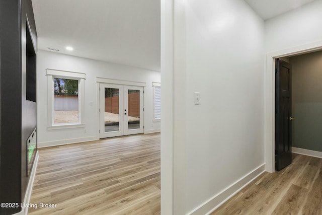 hall featuring french doors and light wood-type flooring