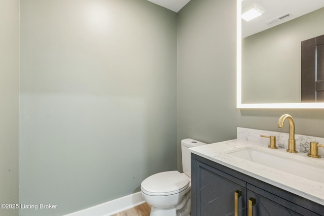 bathroom with vanity, wood-type flooring, and toilet