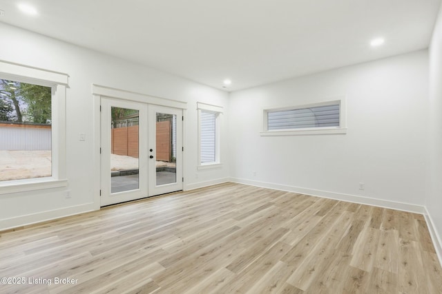 empty room featuring french doors and light wood-type flooring