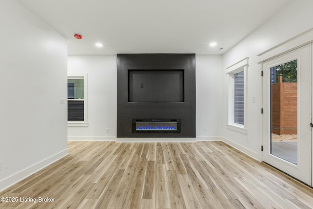 unfurnished living room with a fireplace and light hardwood / wood-style flooring