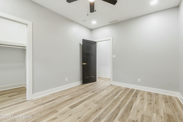 unfurnished bedroom with ceiling fan, light hardwood / wood-style floors, and a closet