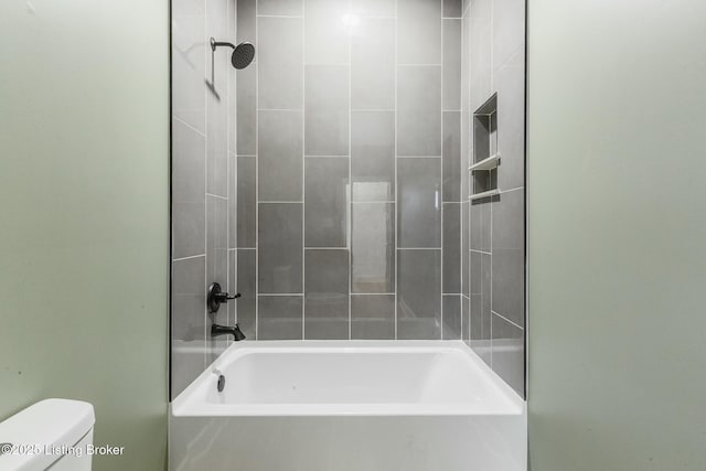 bathroom featuring tiled shower / bath and toilet