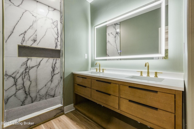 bathroom featuring vanity, hardwood / wood-style flooring, and a tile shower