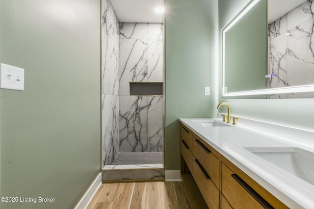 bathroom featuring vanity, hardwood / wood-style flooring, and tiled shower