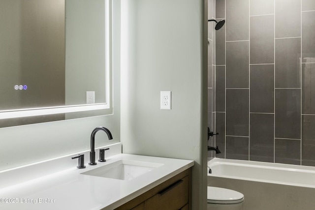 full bathroom featuring tiled shower / bath, vanity, and toilet