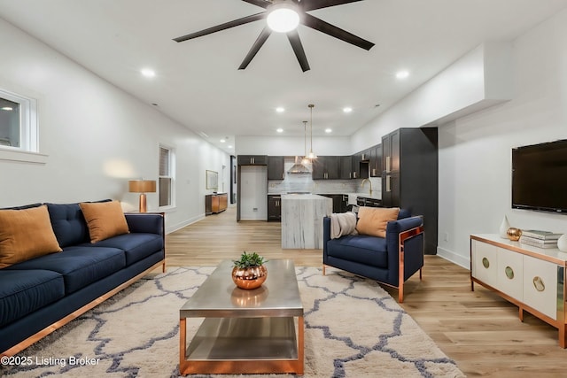 living room with light hardwood / wood-style flooring and ceiling fan