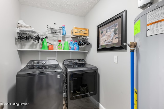 clothes washing area featuring separate washer and dryer, a textured ceiling, and gas water heater