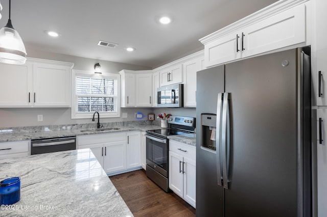 kitchen with appliances with stainless steel finishes, decorative light fixtures, sink, and white cabinets