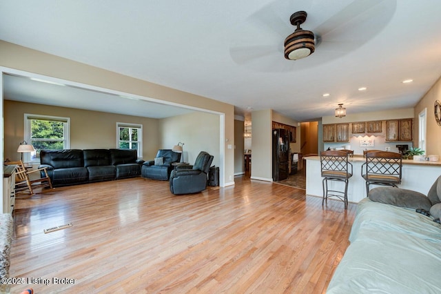 living room featuring ceiling fan and light wood-type flooring