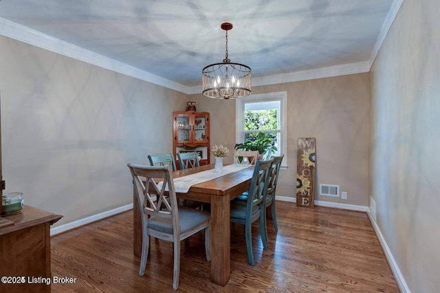 dining space featuring ornamental molding, wood-type flooring, and a chandelier