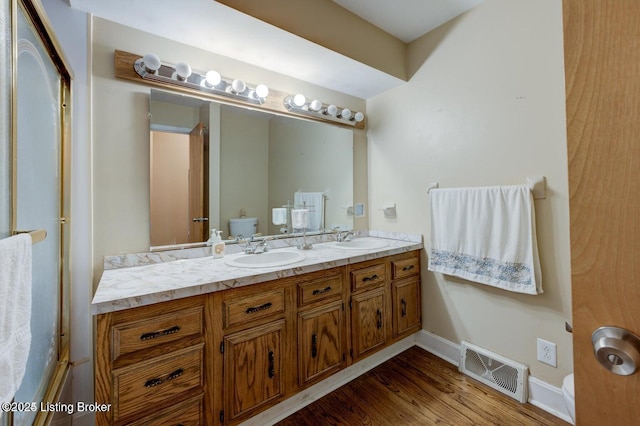 bathroom with hardwood / wood-style flooring, vanity, and toilet