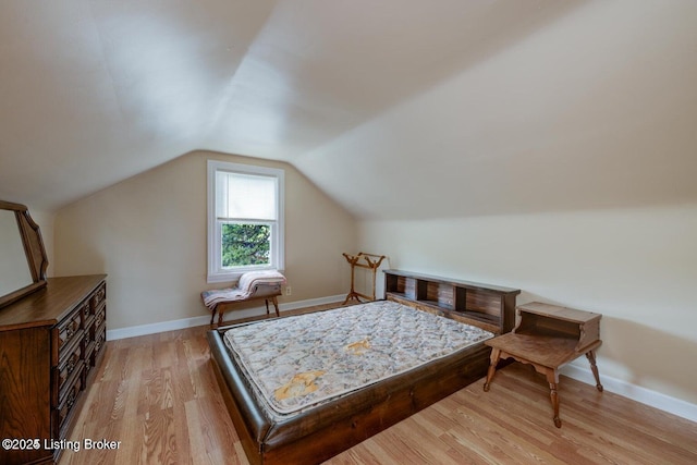 bedroom with light hardwood / wood-style flooring and vaulted ceiling