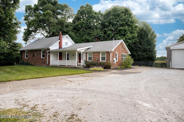 ranch-style home featuring covered porch and a front lawn