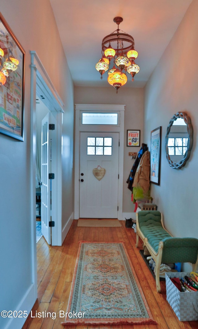 foyer entrance with a chandelier and light hardwood / wood-style floors