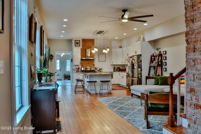 living room with light hardwood / wood-style floors and ceiling fan