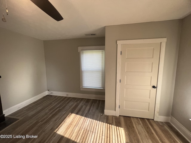 spare room featuring dark wood-type flooring and ceiling fan