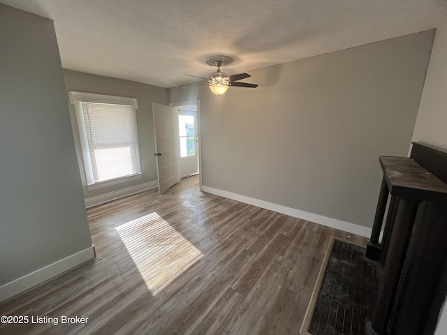 unfurnished room featuring hardwood / wood-style flooring, ceiling fan, and a textured ceiling