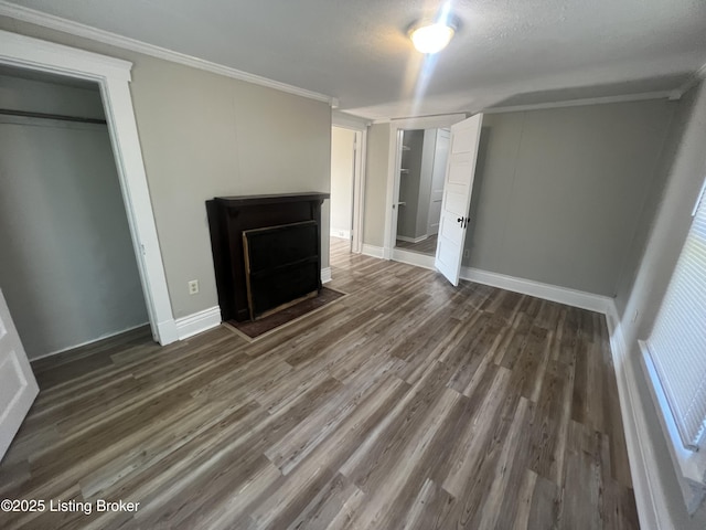 unfurnished bedroom with ornamental molding and dark wood-type flooring