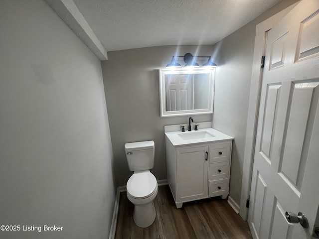 bathroom with vanity, wood-type flooring, a textured ceiling, and toilet