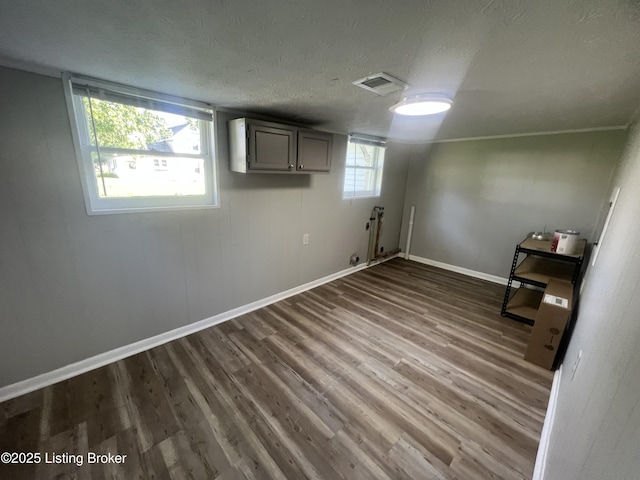 basement featuring dark wood-type flooring and a textured ceiling