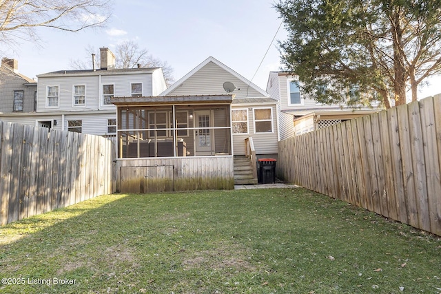 rear view of property featuring a sunroom and a lawn