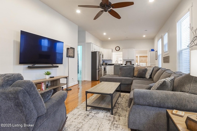 living room with light hardwood / wood-style flooring and ceiling fan