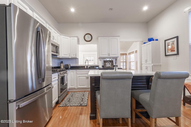 kitchen with white cabinetry, a center island, and appliances with stainless steel finishes