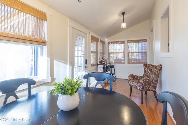 dining room with lofted ceiling and light hardwood / wood-style floors