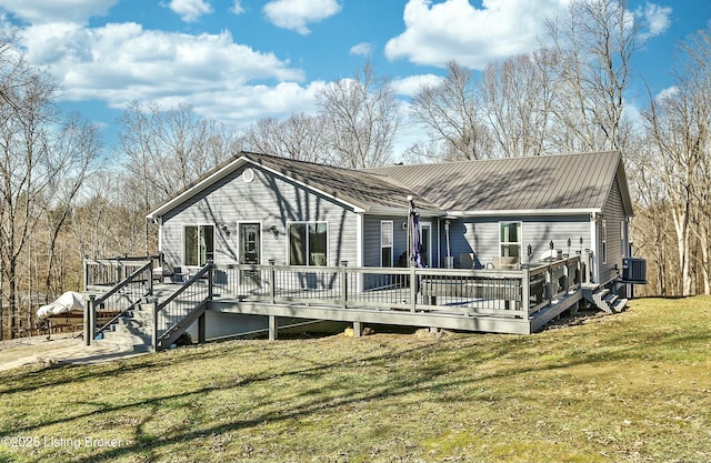 rear view of house featuring a deck and a lawn