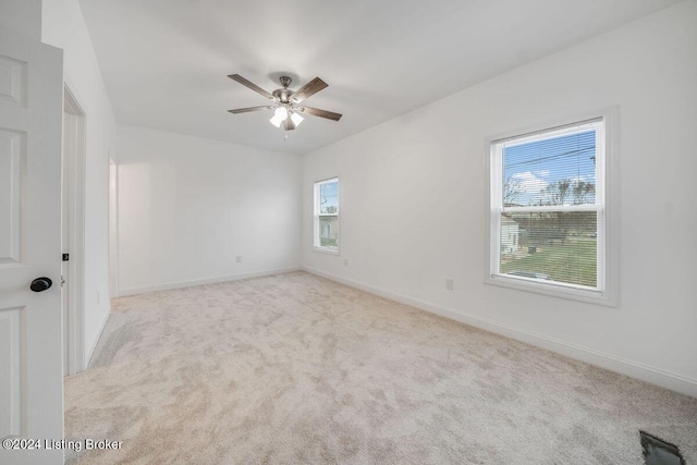 spare room with light colored carpet and ceiling fan