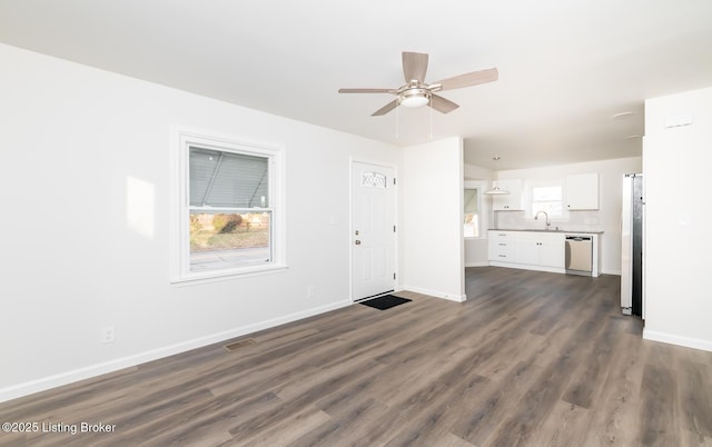 unfurnished living room with dark wood-type flooring, sink, and ceiling fan