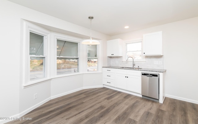 kitchen featuring pendant lighting, sink, white cabinets, decorative backsplash, and stainless steel dishwasher