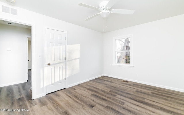 unfurnished room with dark hardwood / wood-style flooring and ceiling fan