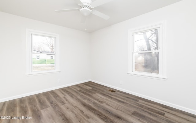 empty room with ceiling fan and dark hardwood / wood-style flooring