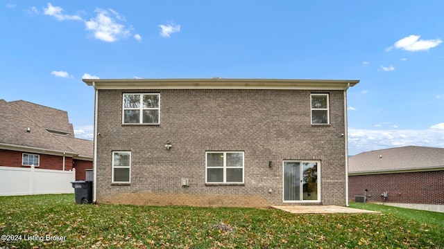 back of property with a yard and a patio