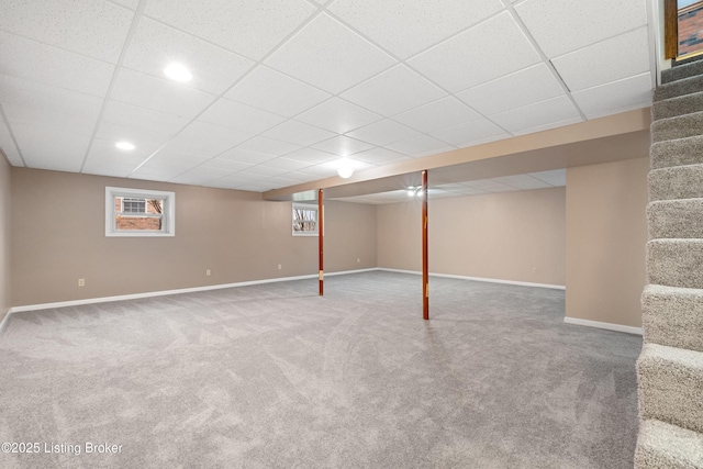 basement with carpet floors and a paneled ceiling