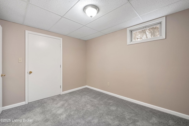 spare room featuring carpet flooring and a paneled ceiling