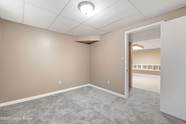 carpeted spare room featuring a drop ceiling