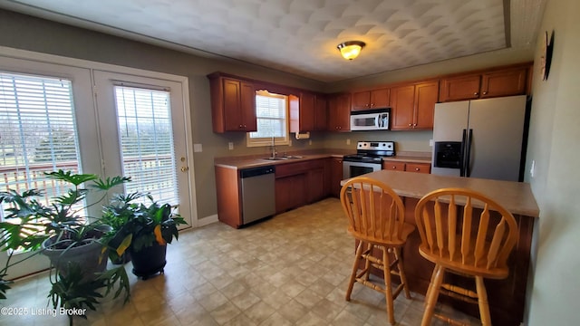 kitchen with stainless steel appliances, a kitchen bar, and sink